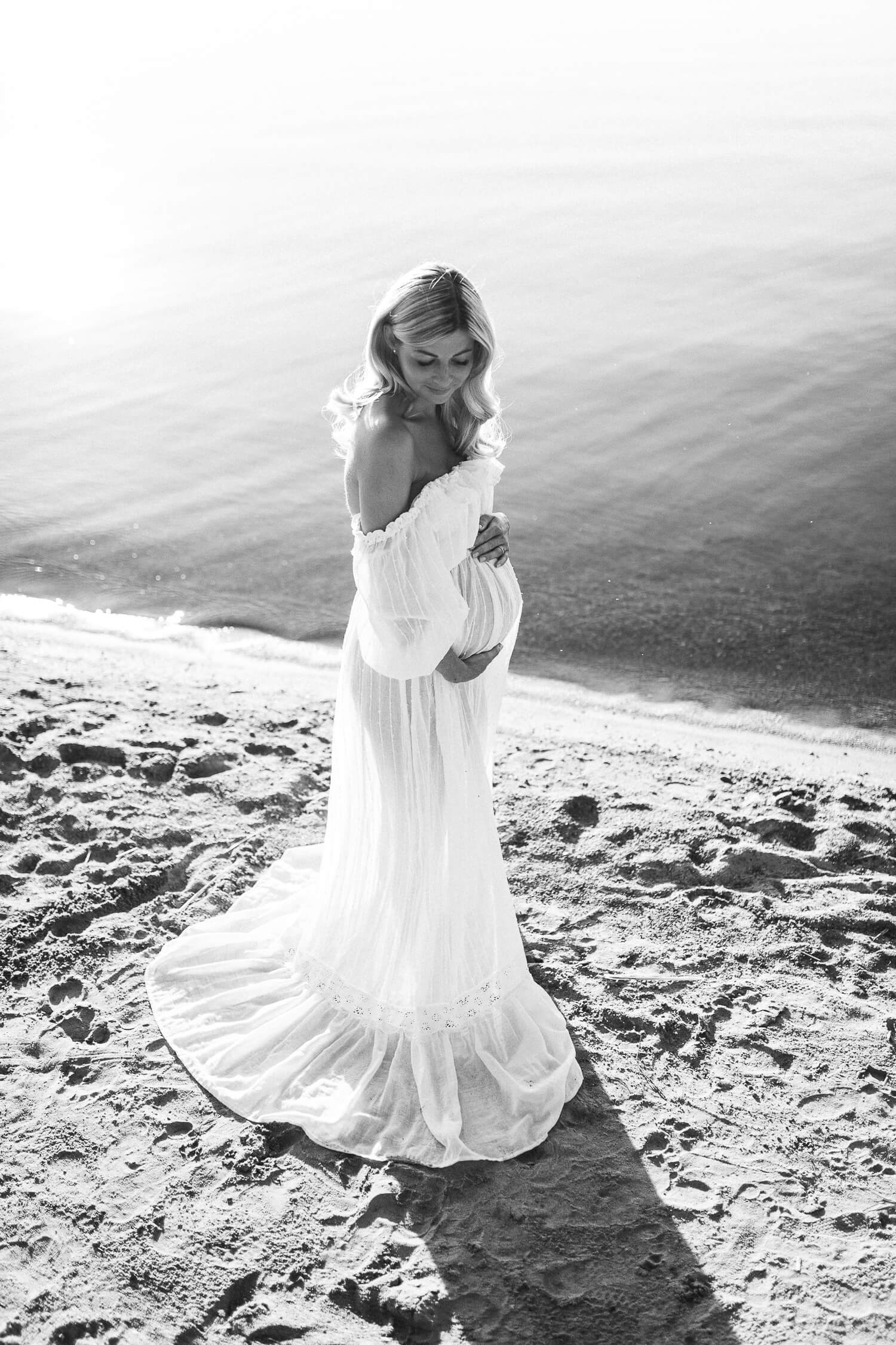 Kaunis odottava äiti rannalla